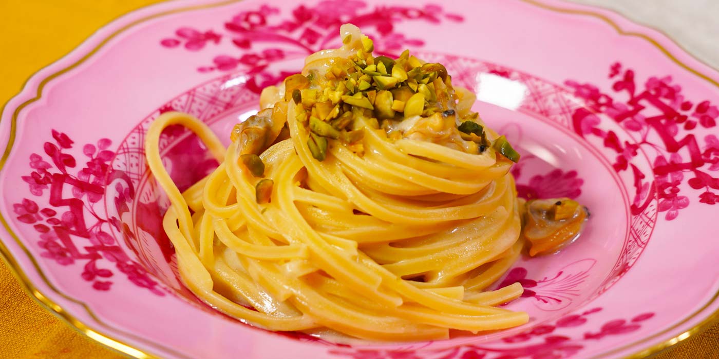 Spaghetti dish on a decorative pink plate with gold trim