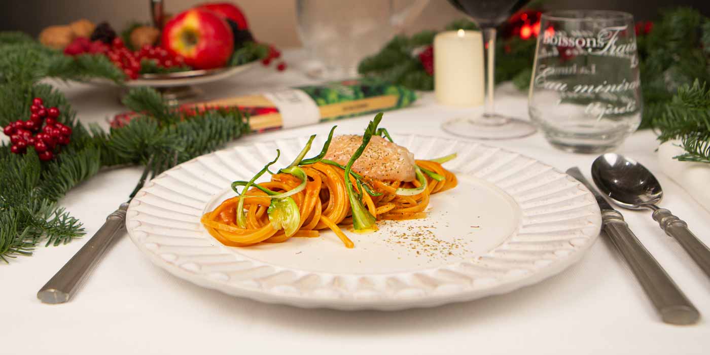 Plate of pasta with a festive background featuring Christmas decorations.